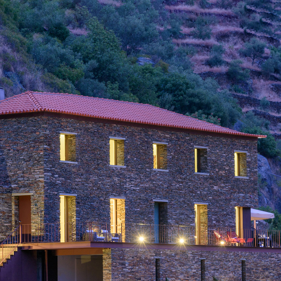 Fachada em xisto da Casa do Rolapipas, iluminada ao entardecer